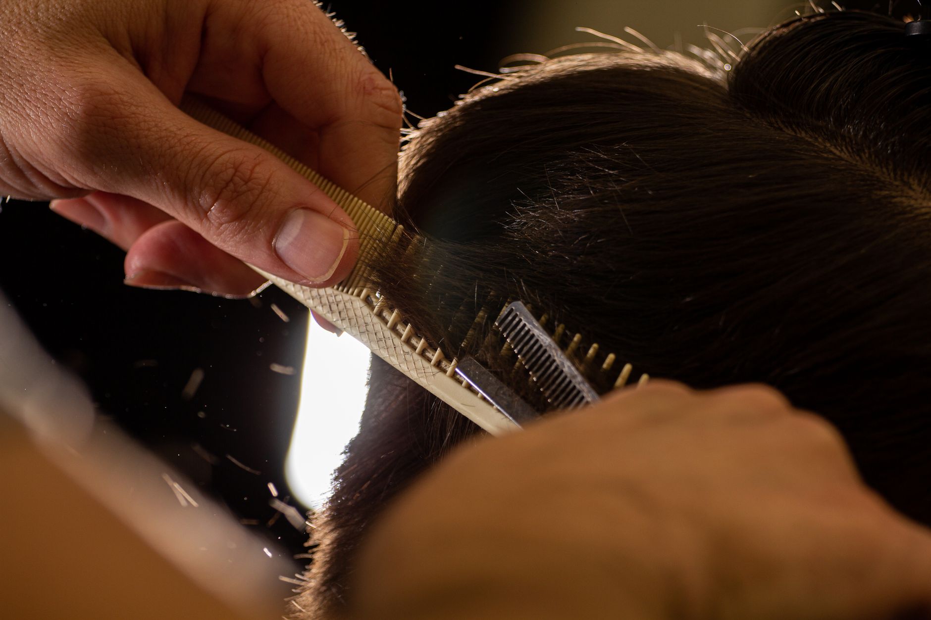 Coiffeur réalisant une coupe en salon